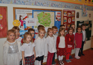 Dzieci z grupy III pozują do wspólnego zdjęcia. Dzieci są we większości przebrane w stroje w polskich kolorach narodowych.